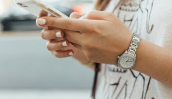 woman holding iPhone during daytime